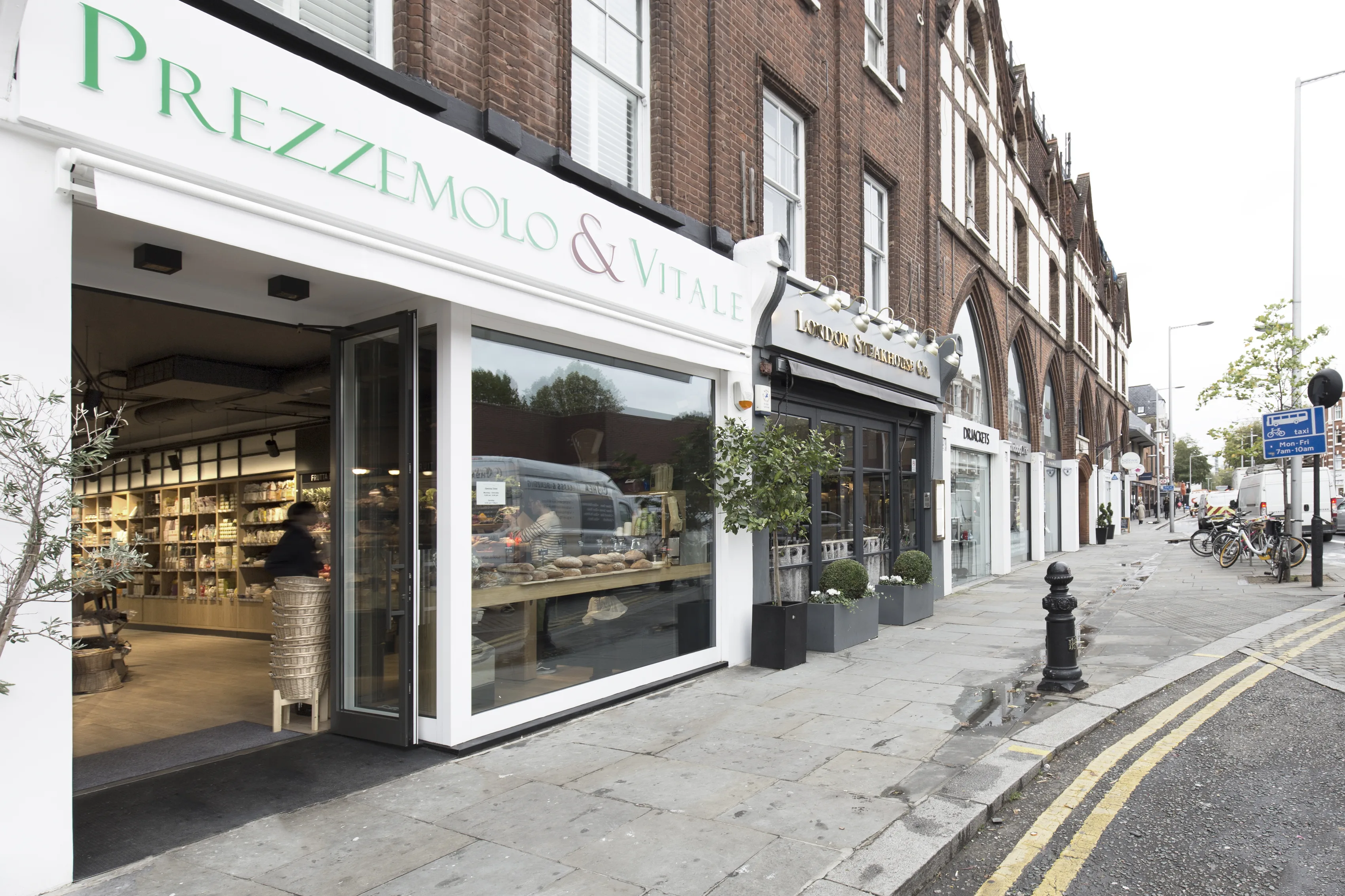 Facciata d'angolo del negozio Prezzemolo & Vitale a Chelsea, con vetrina bianca e porta aperta sulla strada