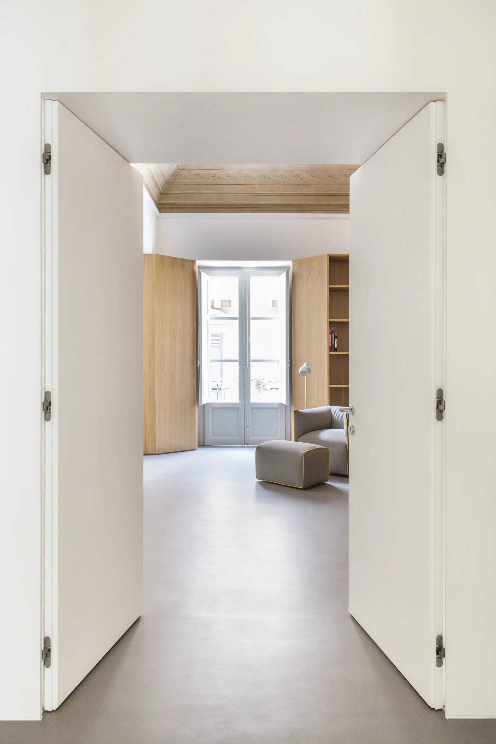 Doors flung open onto a corridor leading to a sitting corner