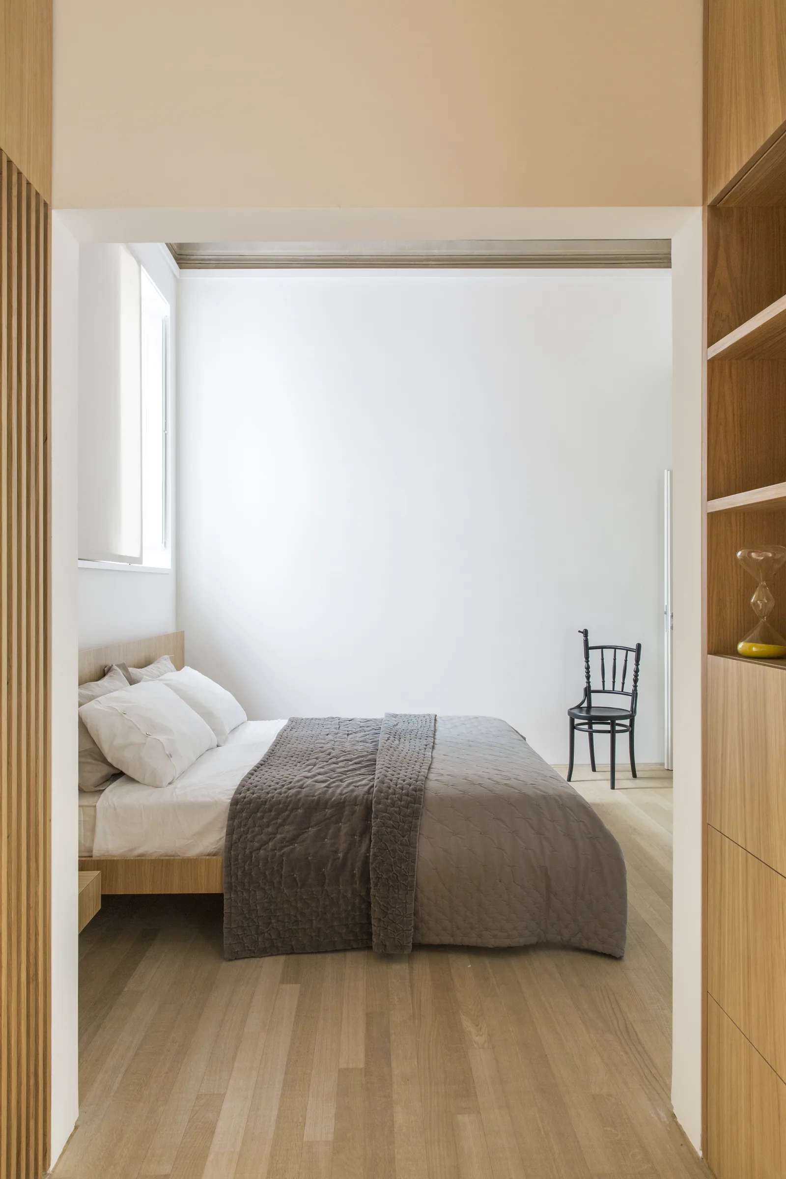 Bedroom in depth, between an oak wall and the window