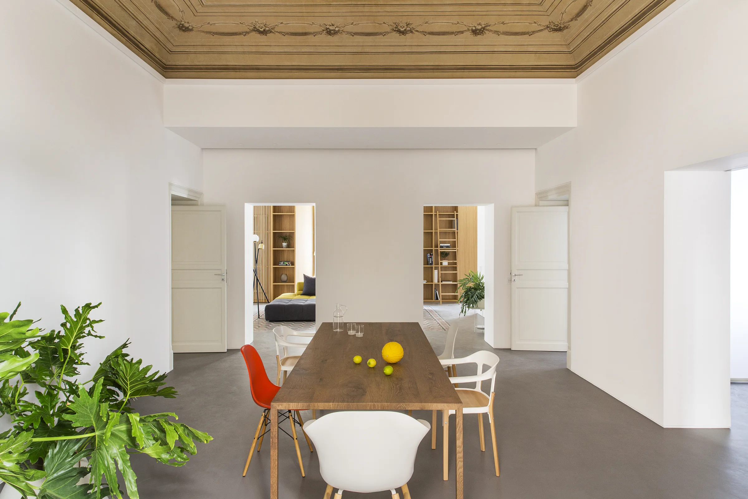 Dining room with painted ceiling, wooden table and white doors at the far end