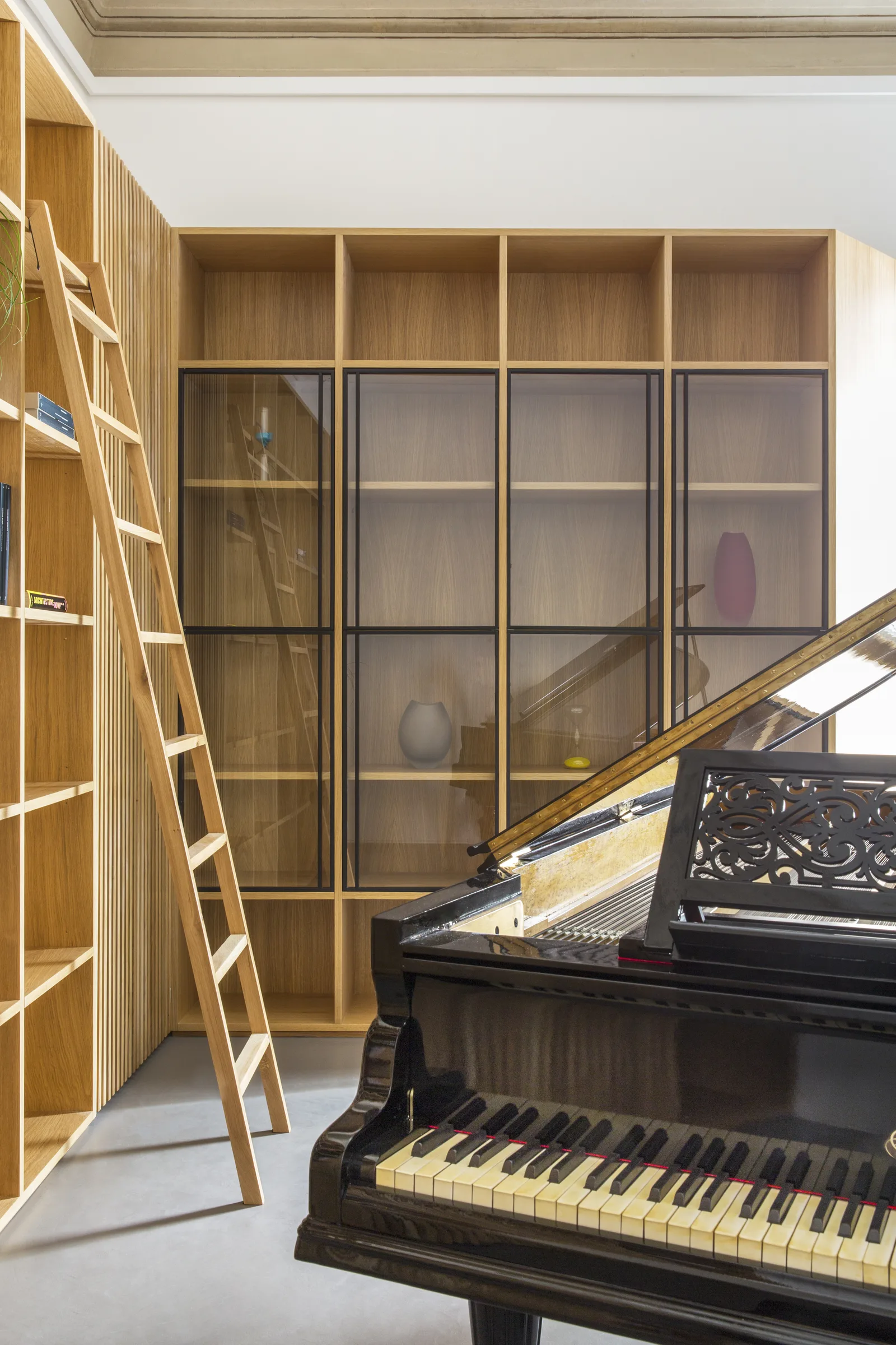 Detail of the piano keyboard with glazed cabinets and the oak ladder