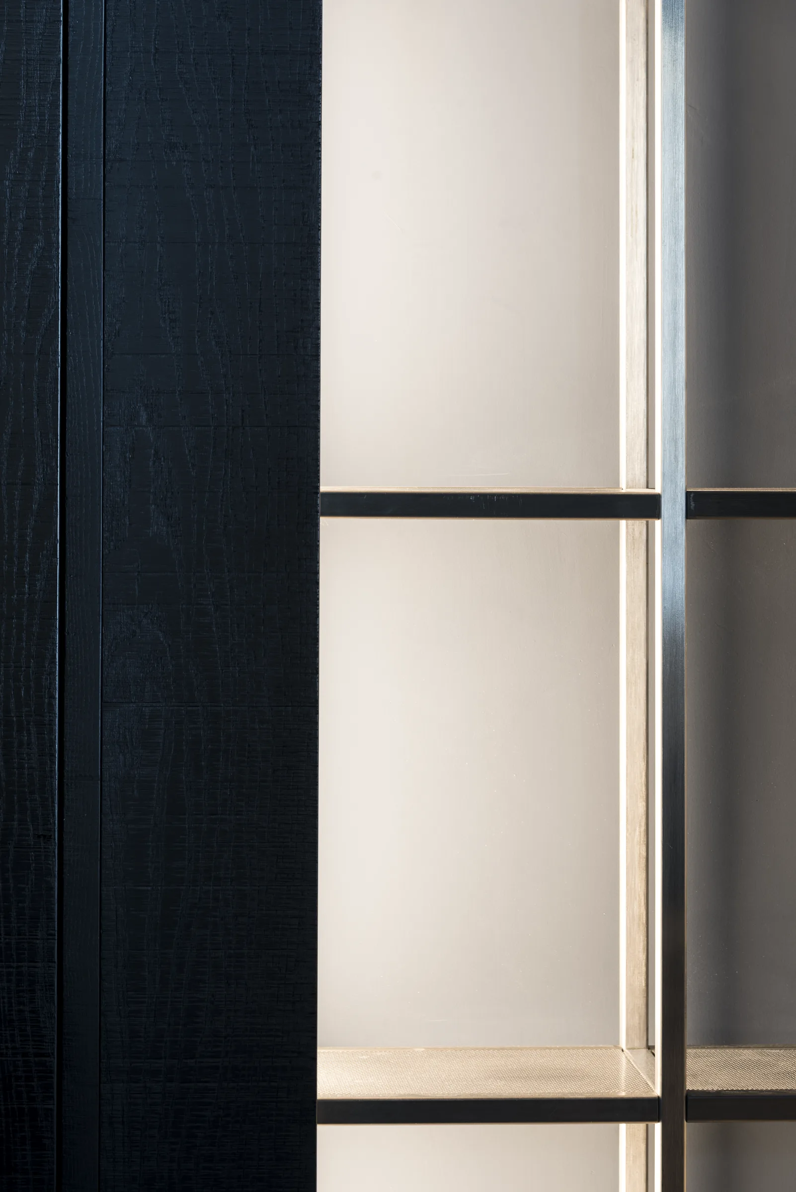 Dettaglio di una porta in legno annerito con vetro opalino e telaio sottile in metallo